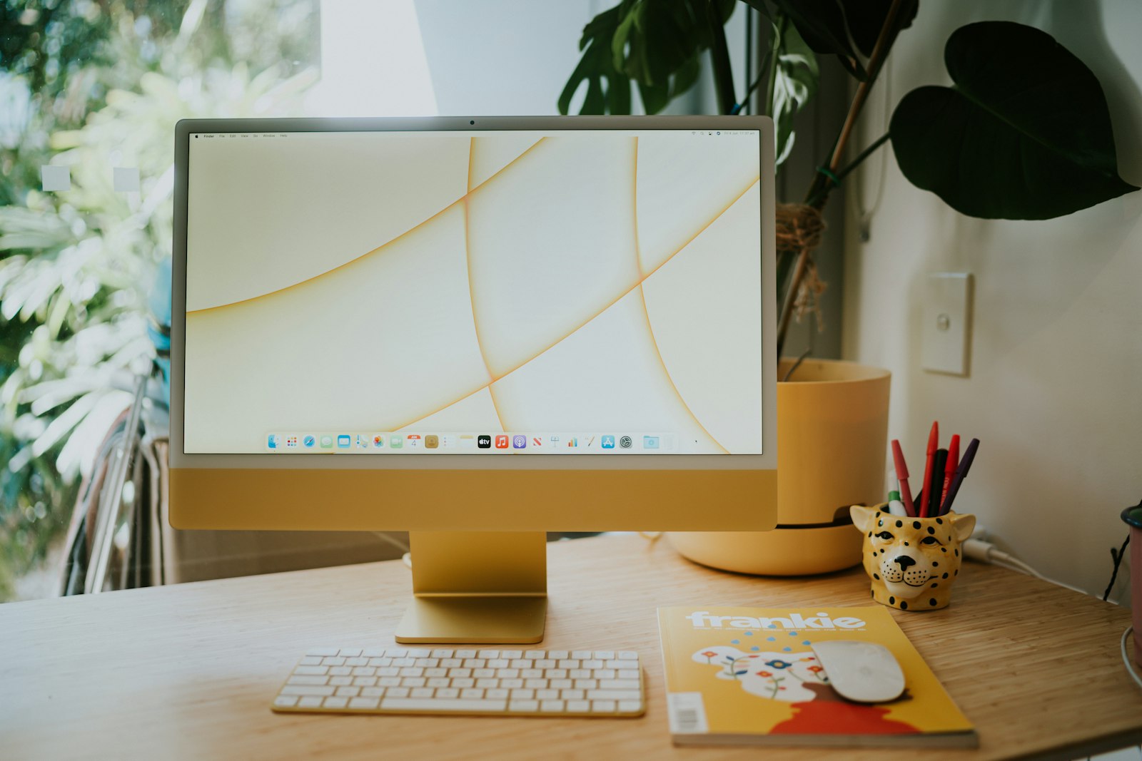 Current 24-inch yellow iMac on a wooden desk; future M6 colors are unconfirmed